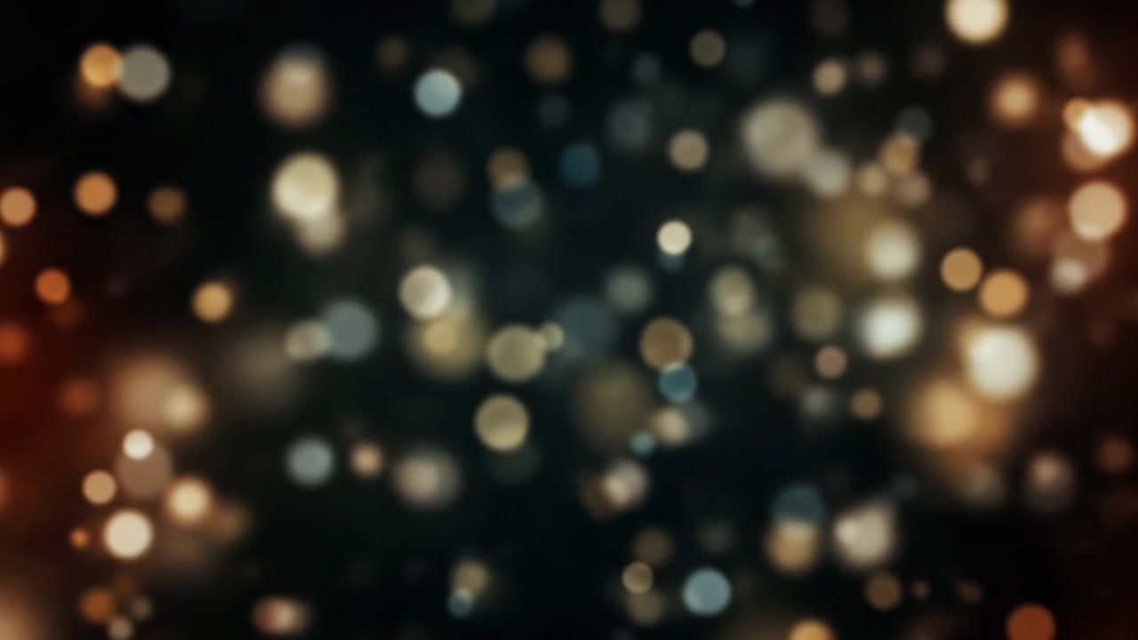 Cerchi di luce morbidi e sfocati brillano su una scena scura, mescolando toni dorati caldi con riflessi bianchi freddi per creare uno sfondo atmosferico festivo.