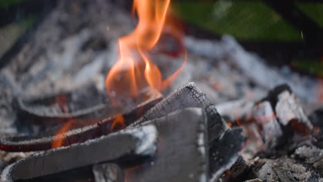 Makro-Nahaufnahme-Von-Holzscheiten,-Die-Am-Boden-Einer-Feuerstelle-In-Zeitlupe-Brennen