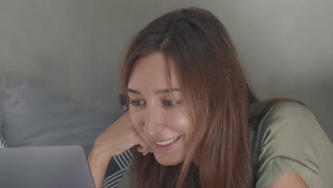 woman video calling lying on stomach