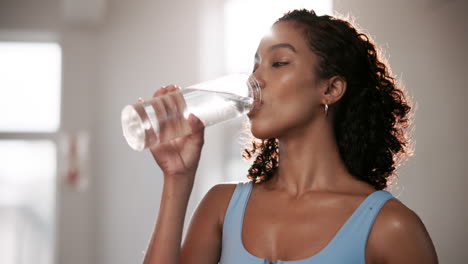 woman drinking water after exercise