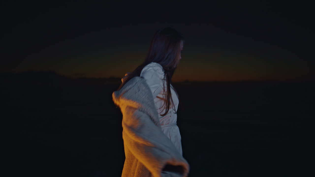 Primo piano di una donna alla moda che balla sulla spiaggia di notte. Modella seducente che posa a una festa.