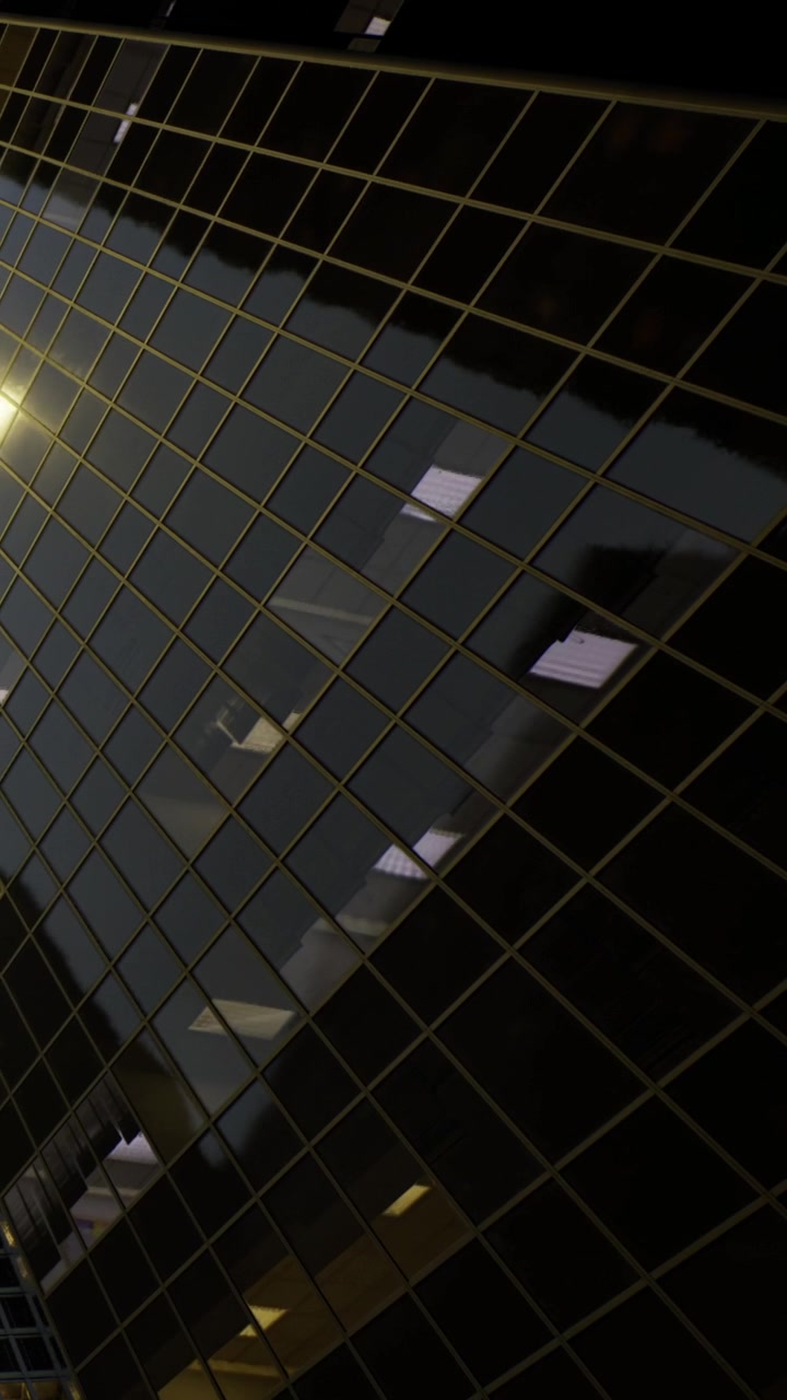 Reflection of lights and shapes on a tiled wall in a city area during evening