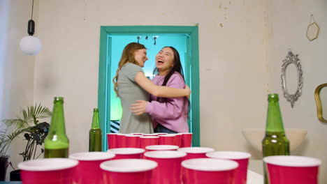 Multiethnic-young-friends-playing-beer-pong-at-home