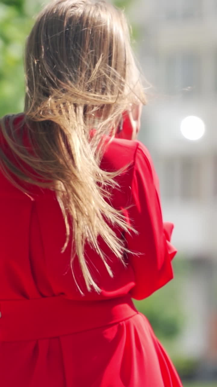 Woman talking on phone. Young charming woman calling with cell phone while walking in park Vertical video