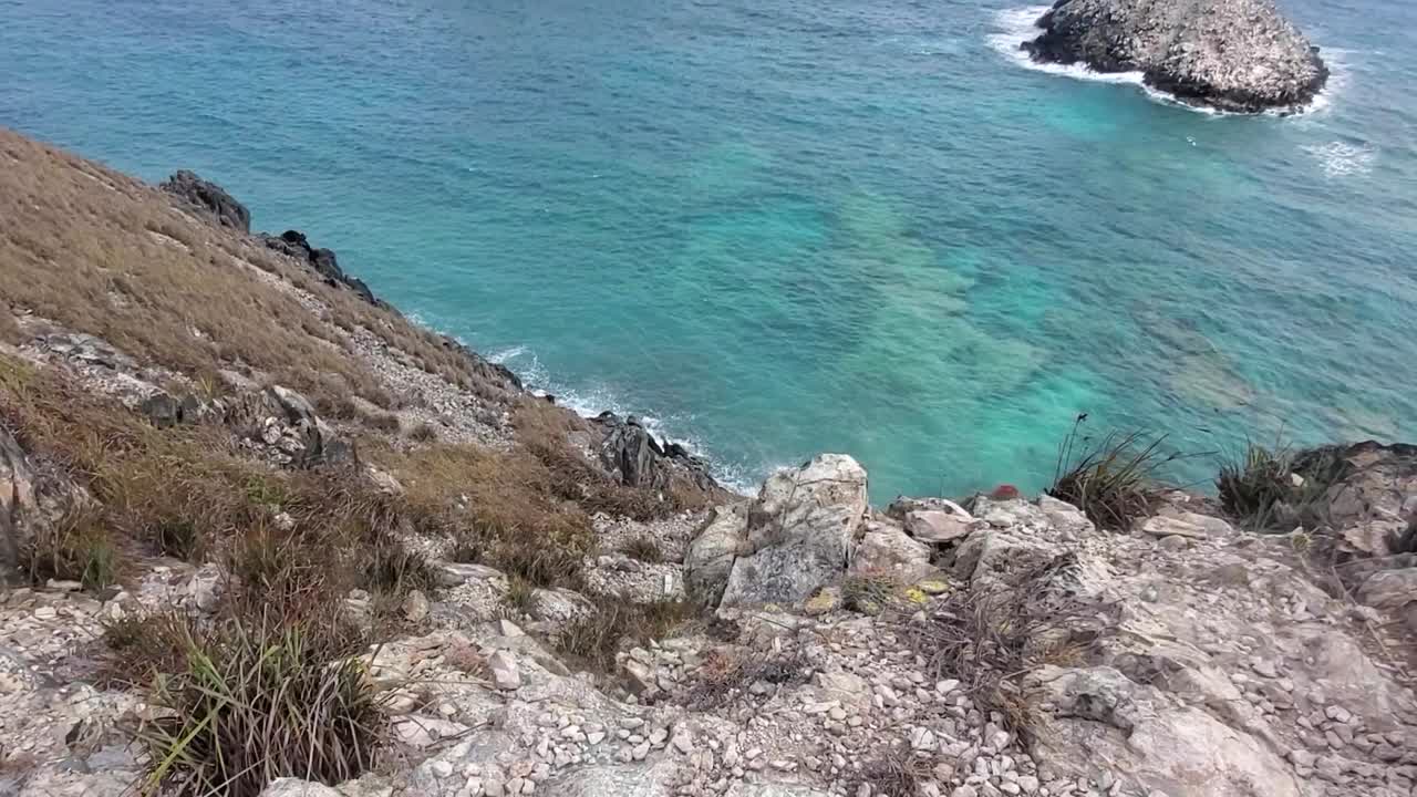 Bordo della scogliera dall'alto, cima della montagna, panoramica verso il basso che rivela l'orizzonte del Mar dei Caraibi, Los Roques