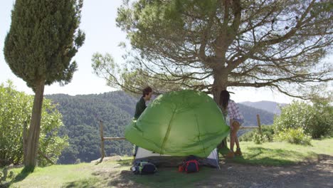 two travellers putting up tent