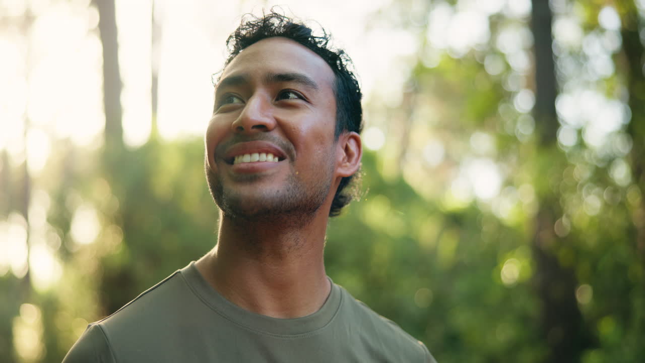 Young Man Looking Up and Smiling in a Sunny Forest