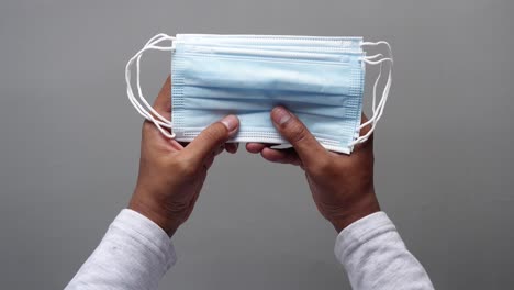 hands holding a stack of disposable face masks