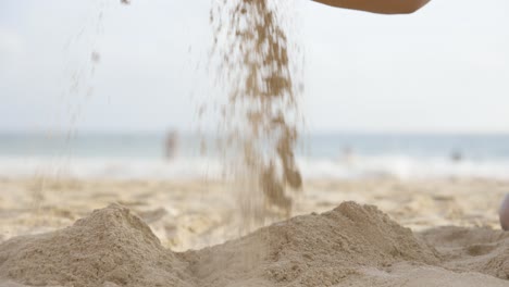 Static-Shot-Of-Girl-Lifting-Sand-Up-With-Her-Hands-With-Beautiful-Sea-Background,-Sri-Lanka