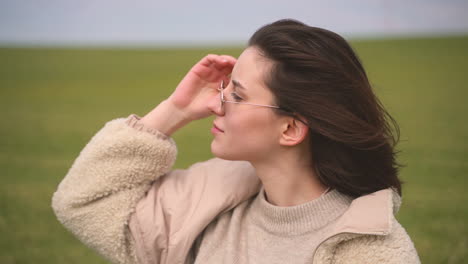 a young beautiful brunette girl in a green meadow