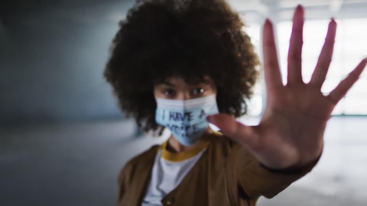 빈 주차장에서 시위 얼굴 마스크를 쓰고 있는 아프리카계 미국인 여성의 초상화