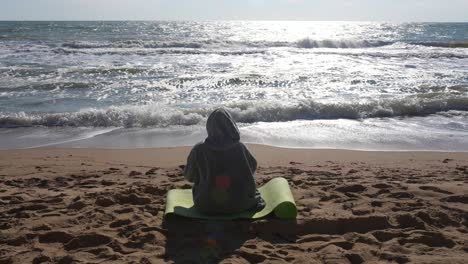 person meditating on the beach