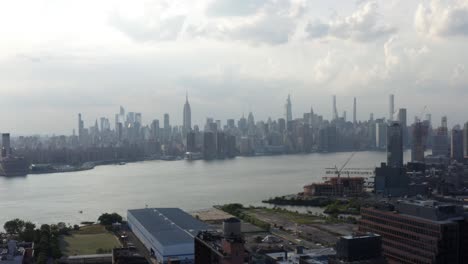 manhattan skyline orbit pan up aerial shot in 4k from brooklyn during sunset