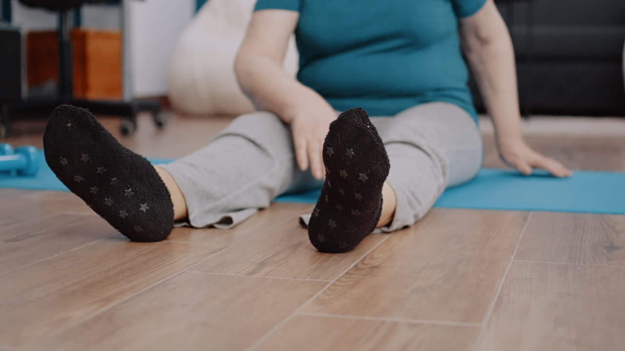 Close up of elder adult stretching arms and legs on yoga mat