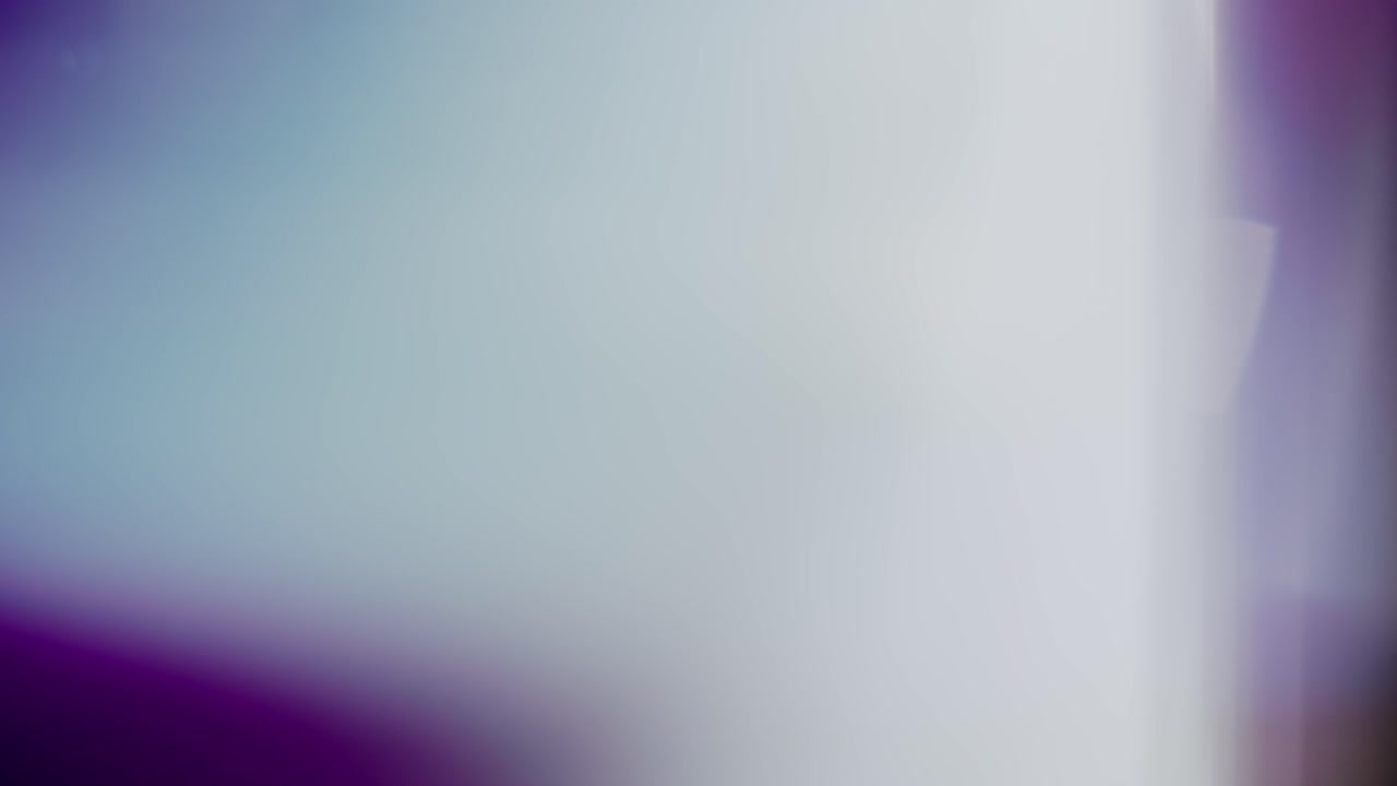 Prismatic light leak pulses slowly over violet tinted backdrop glow Abstract visual for music videos, branding, presentations, and creative intros