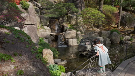 beautiful little girl admiring freshwater and falls scenery at the hwadam botanic garden in gwangju, south korea