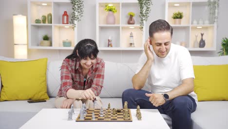 Die-Frau-Schlägt-Ihren-Mann-Beim-Schachspiel.-Glückliches-Paar.