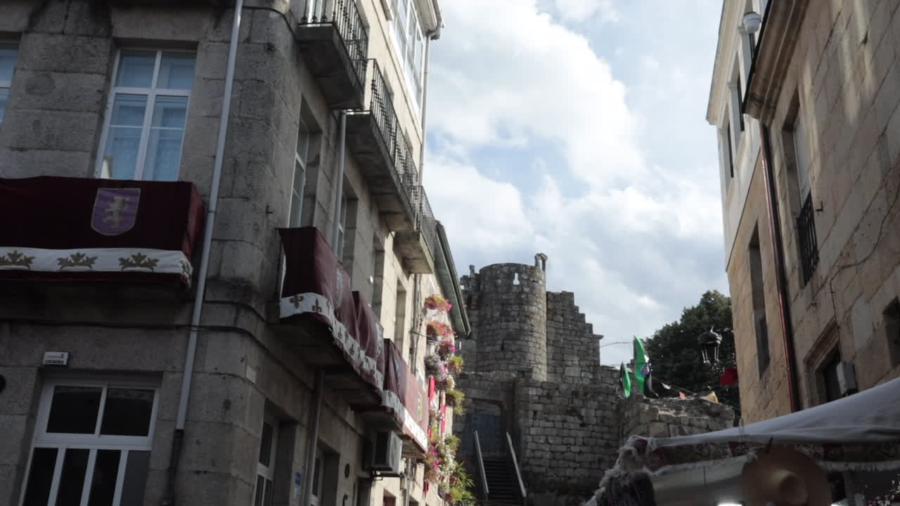 Street view of a historic European building under a bright sky with soft clouds