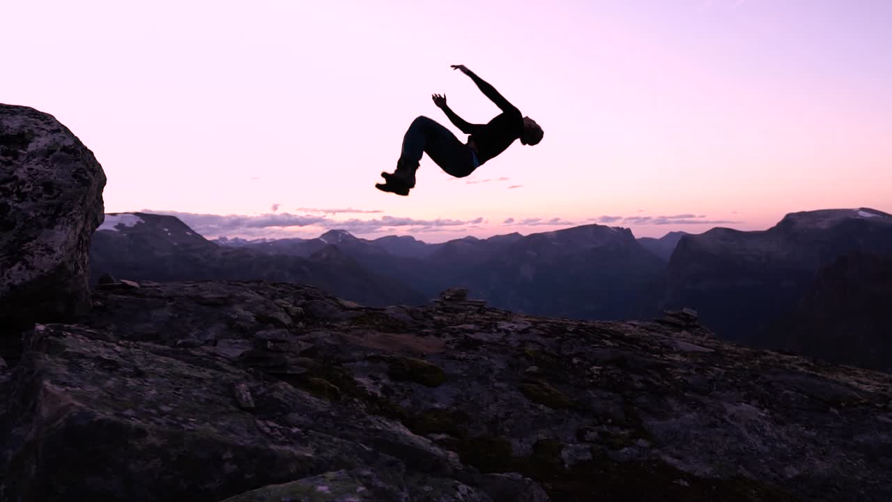 hombre haciendo un salto hacia atrás durante la hermosa puesta de sol en cámara lenta, viviendo la vida al máximo