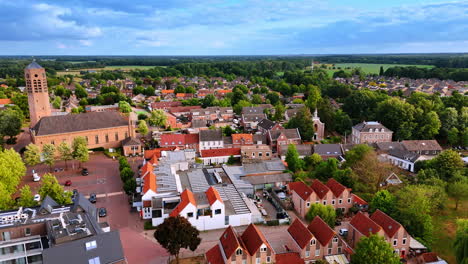 lush greenery surrounding a lovely town with low-rise architecture. drone footage above vierlingsbeek, netherlands