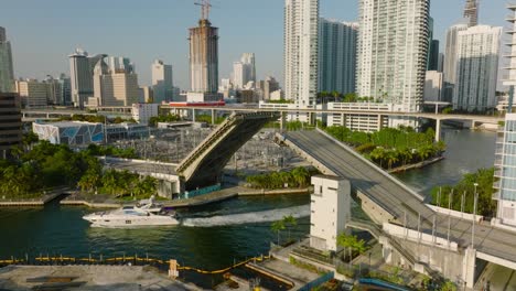 luxury yacht passing under opened lifting bridge. scena from tropical city in sunny late afternoon. miami, usa