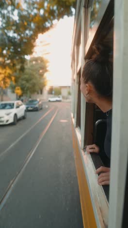 A woman riding a tram through the city