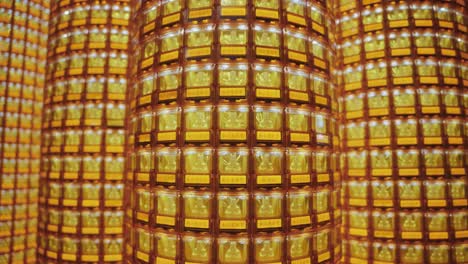 a symmetrical close-up of many towers of golden buddha statues glowing in illuminated niches at ciyou temple in taiwan, symbolizing devotion, peace, and spiritual reverence in a sacred buddhist space