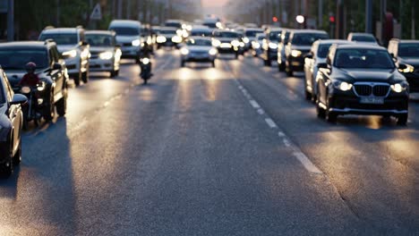 multiple cars traveling along a highway at sunset, headlights illuminating the scene and creating vibrant streaks of light on the wet asphalt, capturing the essence of evening traffic