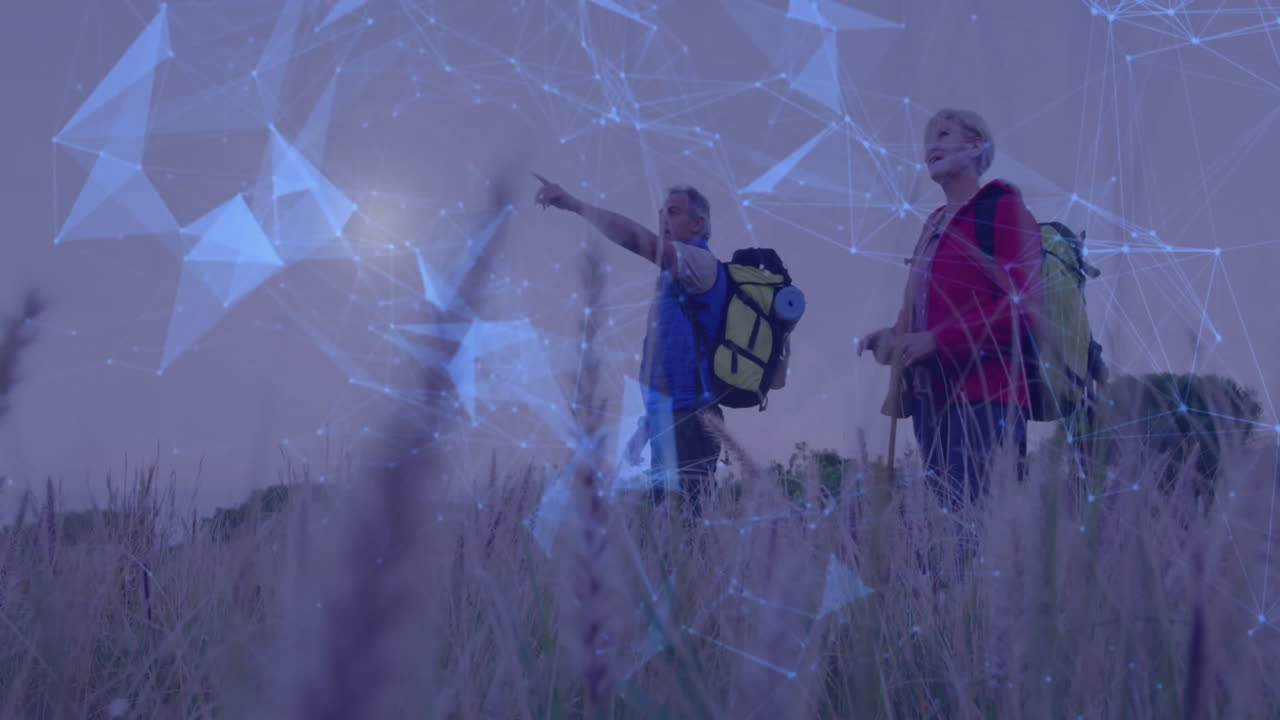 Hiking couple walking through tall grasses at dusk, showing floating technology network graphics