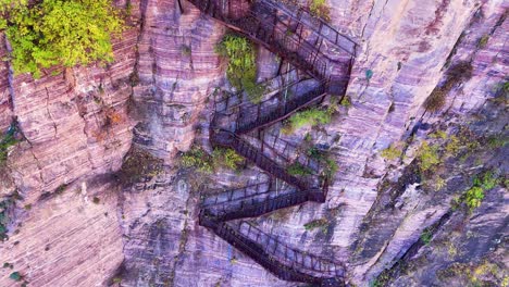 aerial view of a zigzag stairway carved into the stone cliffs near xiuyan village, zhejiang province, china, blending rugged natural beauty with human ingenuity.