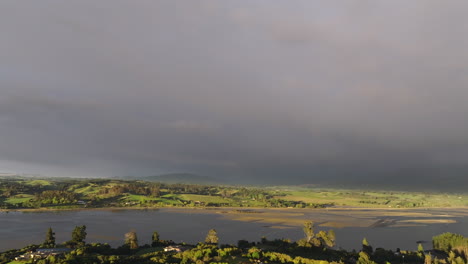 aerial drone shot of rain clouds on the horizon over the motueka valley, new zealand