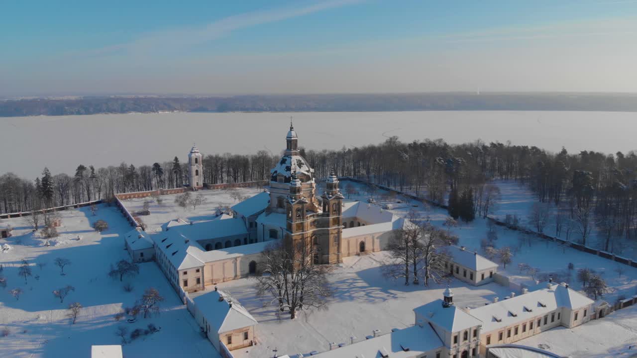 Aerial view of the Pazaislis monastery and the Church of the Visitation in Kaunas, Lithuania in winter, snowy landscape, Italian Baroque architecture, flying back from monastery