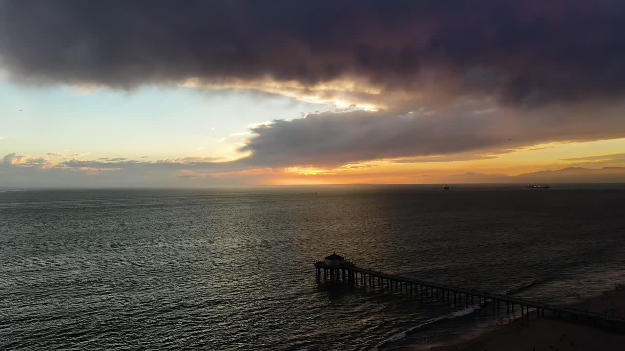 вид с воздуха на силуэт аквариума "раундхаус" во время заката на пляже манхэттен, калифорния, сша