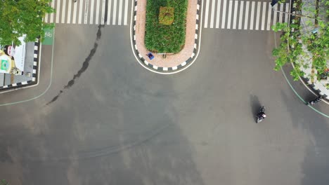 aerial view of a city street intersection with crosswalks and roundabout