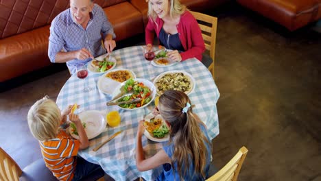 family interacting with each other while having food 4k