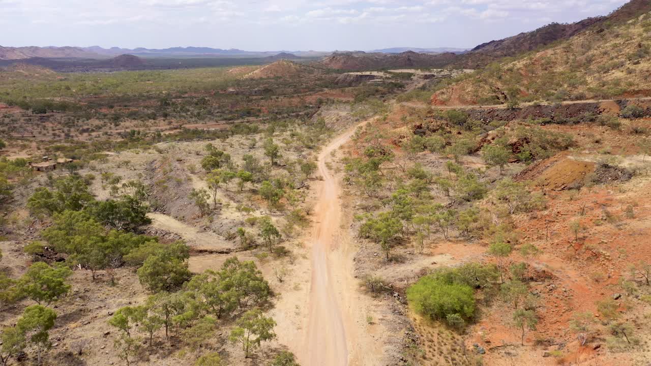 Paesaggio arido e secco con strada sterrata, ripresa aerea nell'Outback del Queensland, Australia.