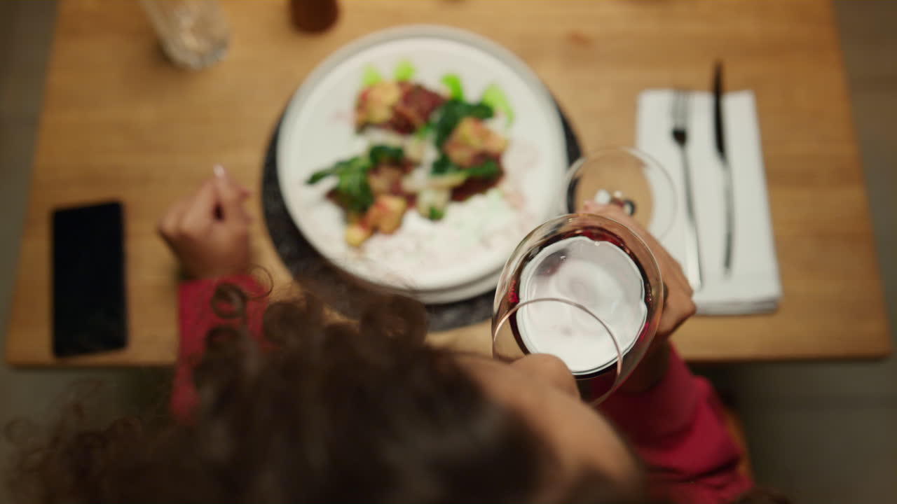 Woman eating restaurant meal drinking wine glass. Enjoy evening date concept.