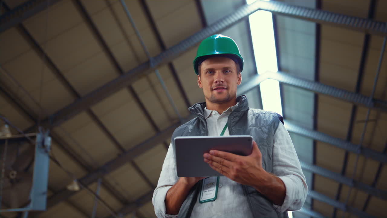 Farmer working tablet computer in shed. Agricultural engineer posing alone.