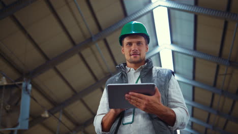 agricultor trabajando con una tableta en el cobertizo. ingeniero agrícola posando solo.