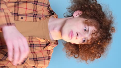 promotional video of a young guy with an interesting hairstyle on a blue background promotional video of a young guy with an interesting hairstyle on a blue background video shooting in the studio a calm focused young man