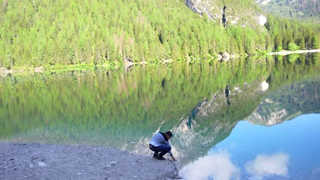 Handaufnahme-Eines-Mannes,-Der-Das-Wasser-Am-Lago-Di-Braies,-Italien,-Inspiziert