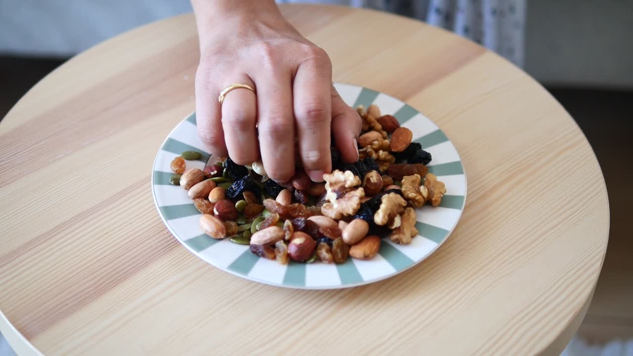 Primo piano di una mano che raccoglie frutta secca mista e frutta disidratata salutare