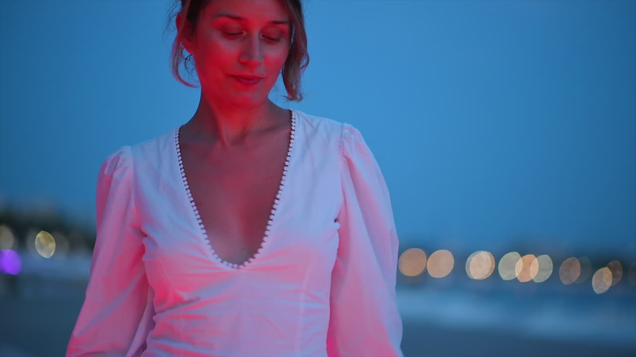 Woman in white dress walking in Cannes embankment street, France