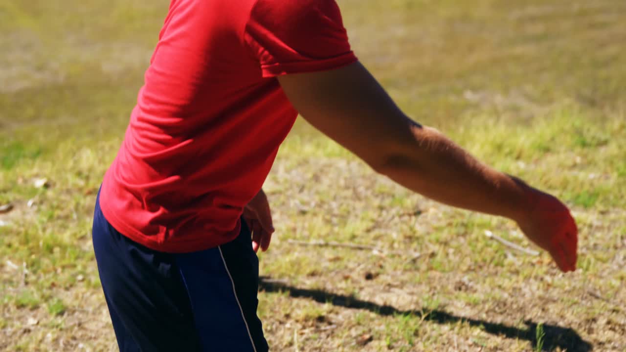 Çocuklar engelli parkur antrenmanı sırasında ağın altından sürünüyor.