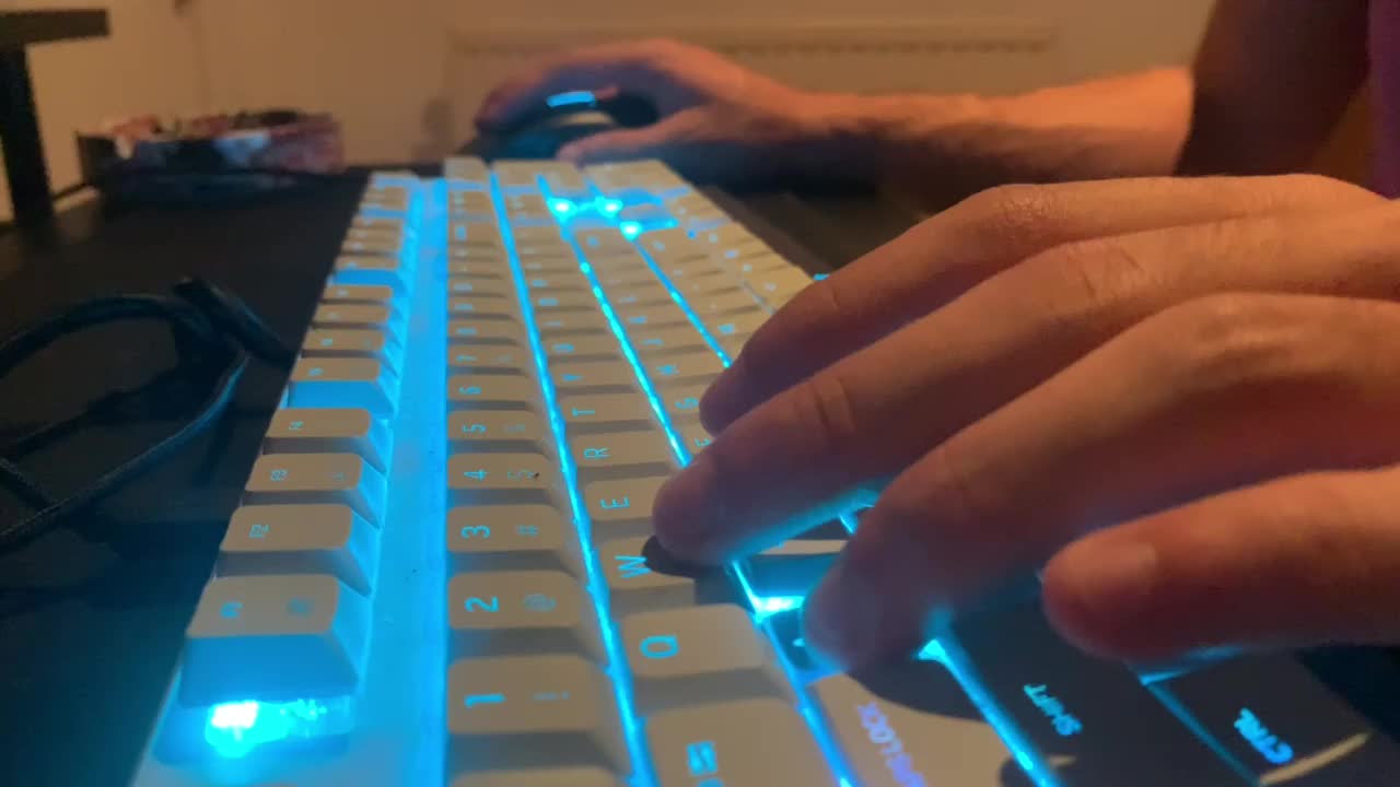 jugador usando el ratón de la pc y el teclado con luz azul
