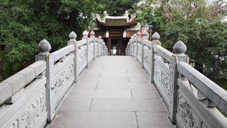 crossing a stone bridge towards a temple