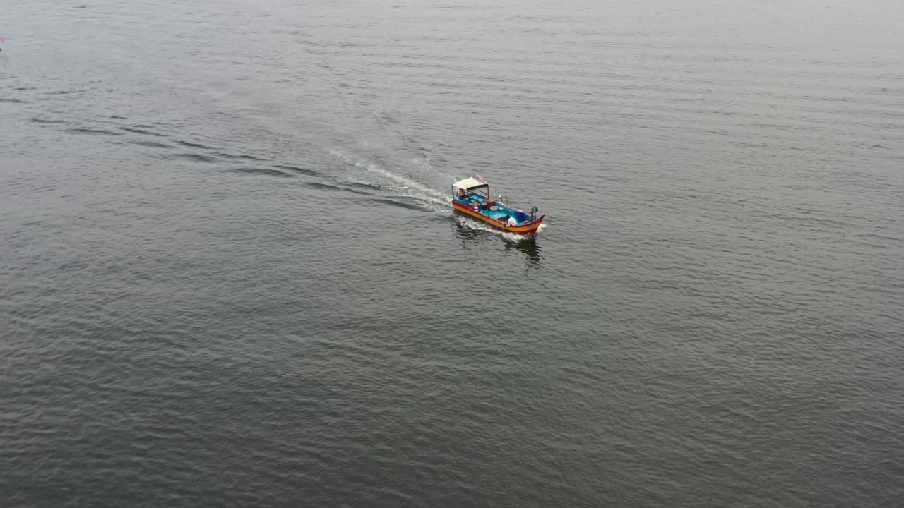Fisherman dropped fishing net into the sea, traditional fishing boat sailing on the sea  out for a morning catch at lumut, mnajung, malaysia, southeast asia, fishery industry shot.