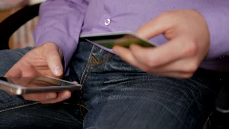hombre de negocios con una camisa púrpura haciendo pago en línea con tarjeta de crédito y teléfono inteligente, compras en línea, tecnología de estilo de vida. hombre introduce el número de tarjeta bancaria en el teléfono inteligente. primer plano. primer plano