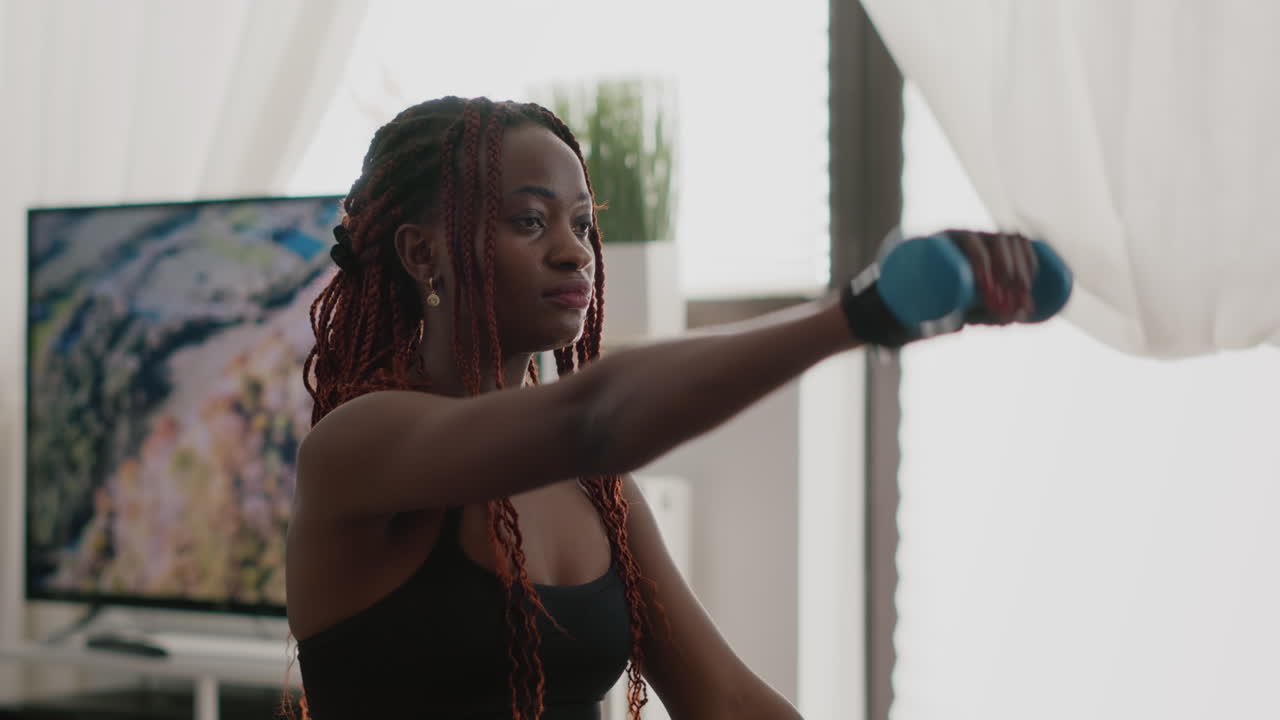 Slim black woman trainer with training exercising body exercises with yoga dumbbells