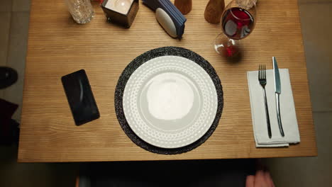 la mano del camarero poniendo el plato de comida en la mesa del restaurante de lujo. delicioso plato de cena